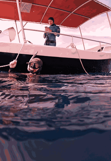 Julian in the water beside the boat